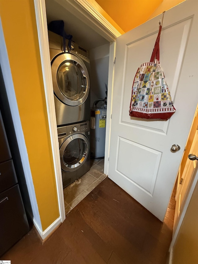 washroom with dark hardwood / wood-style floors, water heater, and stacked washer / dryer