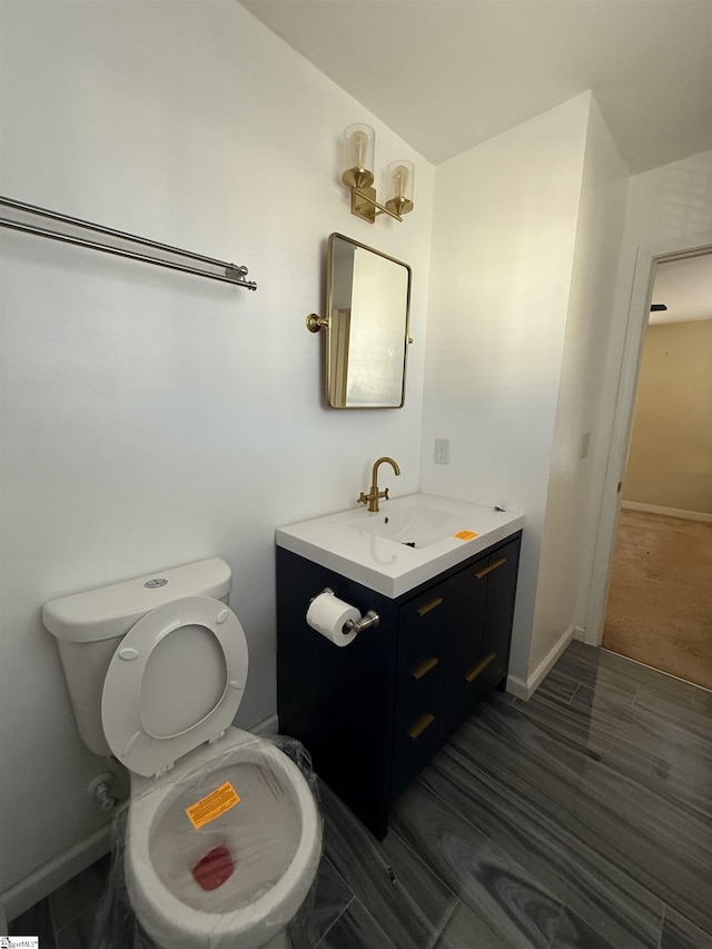 bathroom featuring vanity, hardwood / wood-style floors, and toilet