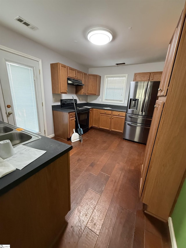 kitchen featuring black / electric stove, sink, stainless steel fridge, and dark hardwood / wood-style floors