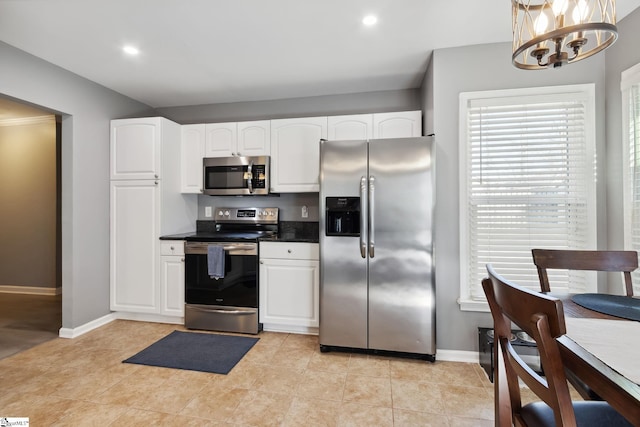 kitchen with white cabinetry, light tile patterned floors, stainless steel appliances, and an inviting chandelier