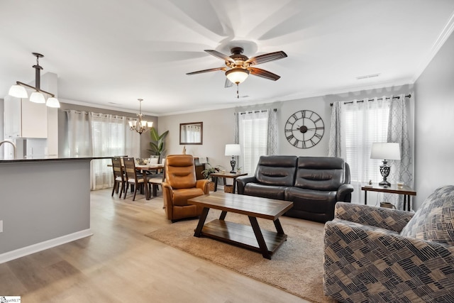 living room featuring sink, ceiling fan with notable chandelier, ornamental molding, and light wood-type flooring