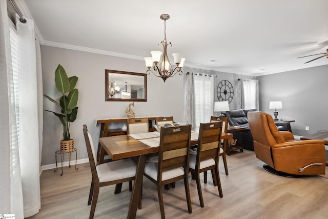 dining room with ornamental molding, ceiling fan with notable chandelier, and light wood-type flooring