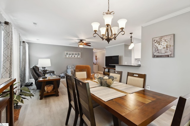 dining space with ceiling fan with notable chandelier, ornamental molding, and light hardwood / wood-style floors