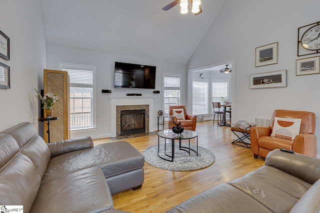 living room featuring ceiling fan, high vaulted ceiling, and light hardwood / wood-style floors