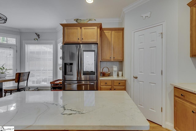 kitchen featuring crown molding, stainless steel fridge, a kitchen island, and backsplash