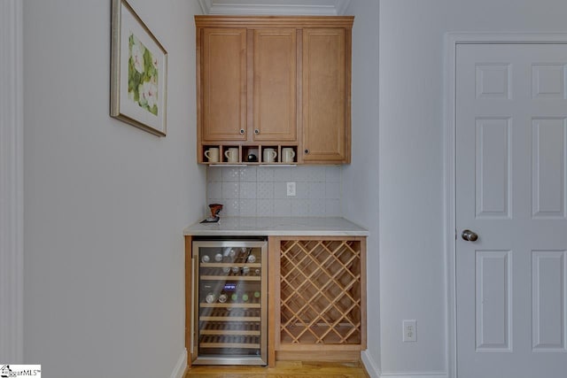 bar featuring wine cooler, crown molding, and decorative backsplash