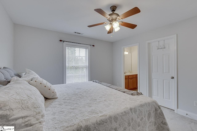 carpeted bedroom with ceiling fan and ensuite bath