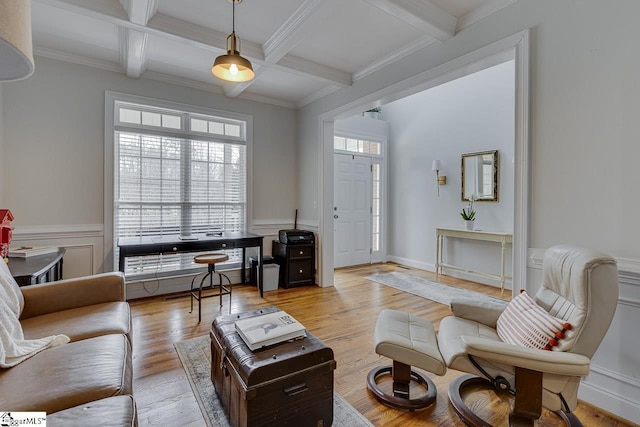 living room with coffered ceiling, ornamental molding, beam ceiling, and light hardwood / wood-style flooring