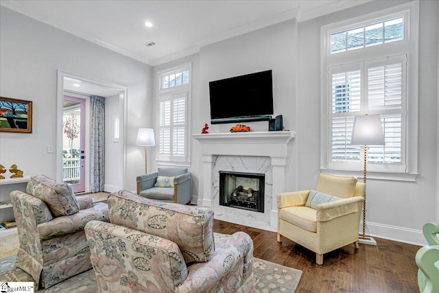 living room with a high end fireplace, dark wood-type flooring, and ornamental molding