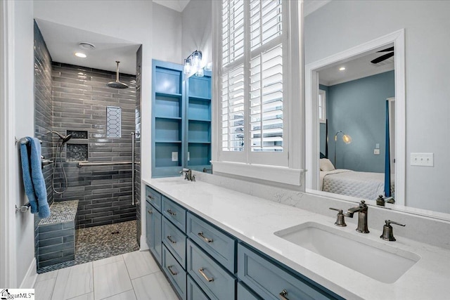 bathroom with vanity, tiled shower, and tile patterned floors