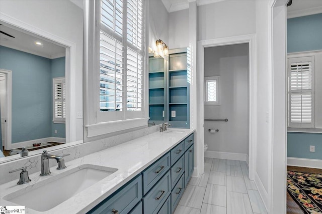 bathroom featuring vanity, ornamental molding, and toilet