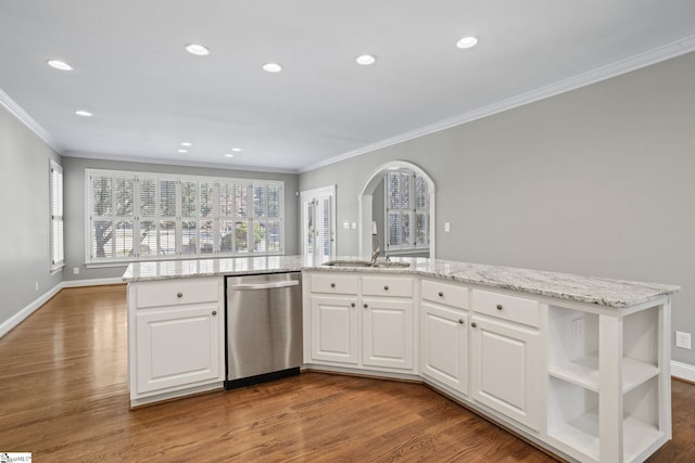 kitchen with wood-type flooring, ornamental molding, stainless steel dishwasher, and white cabinets