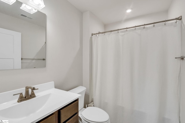 bathroom with vanity, curtained shower, and toilet