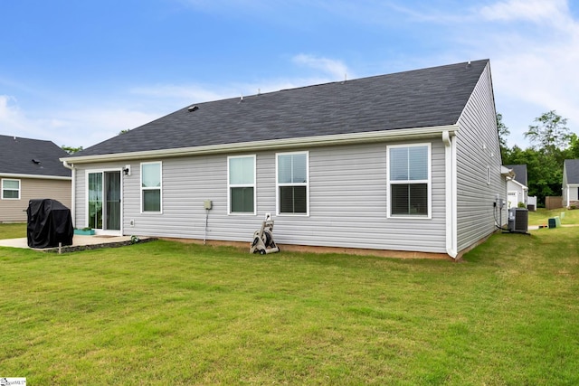 rear view of property with a patio area, a lawn, and central air condition unit