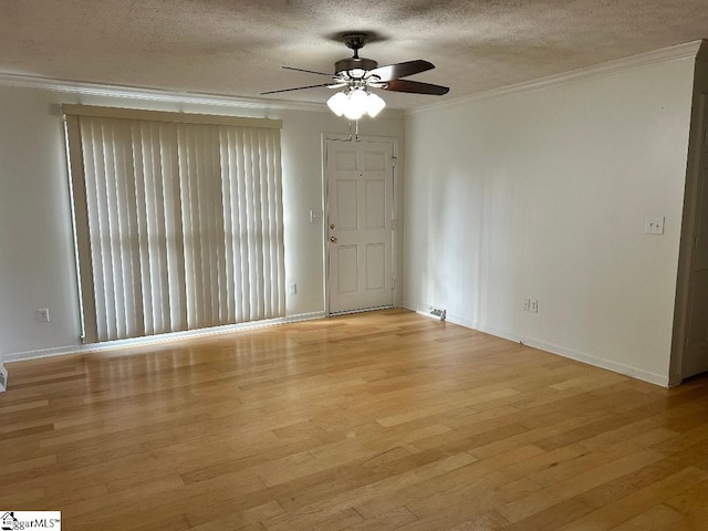 empty room with ornamental molding, ceiling fan, a textured ceiling, and light wood-type flooring