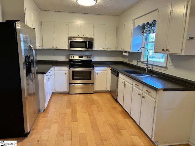 kitchen featuring stainless steel appliances, white cabinetry, and sink