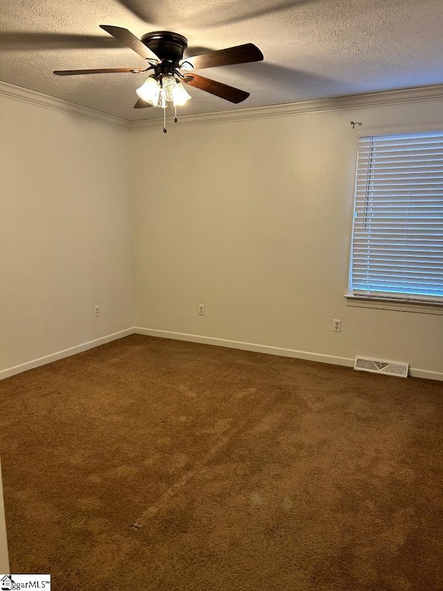 unfurnished room with ceiling fan, dark carpet, ornamental molding, and a textured ceiling