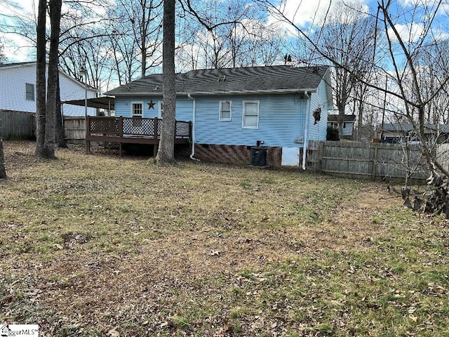 rear view of property featuring a wooden deck, a yard, and central air condition unit