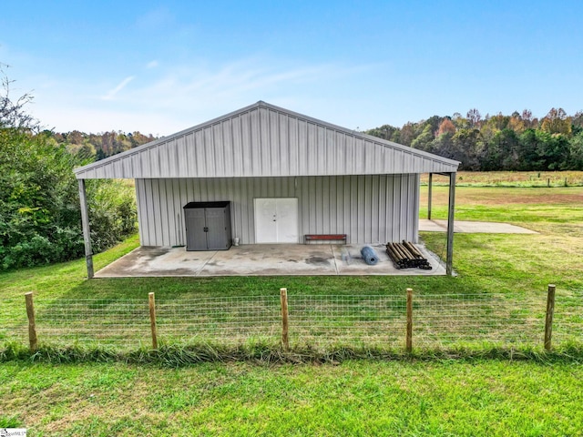 view of outdoor structure with a rural view and a yard