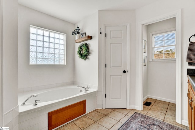 bathroom featuring tile patterned flooring and a relaxing tiled tub