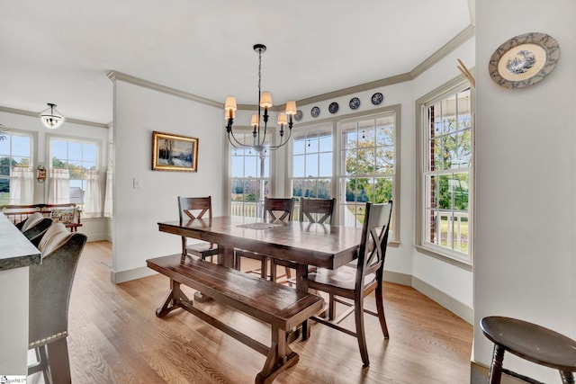 dining space with crown molding, a chandelier, light hardwood / wood-style floors, and a wealth of natural light