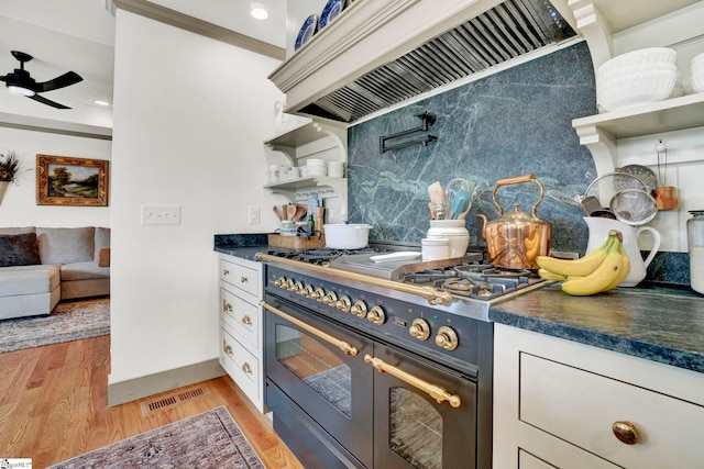 kitchen with crown molding, double oven range, custom range hood, ceiling fan, and light hardwood / wood-style floors