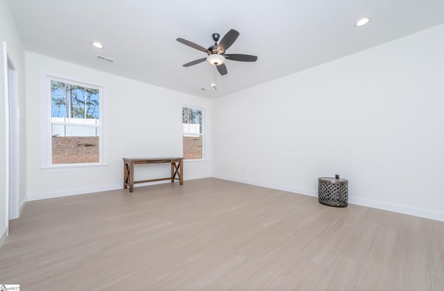 living room featuring a wealth of natural light, ceiling fan, and light hardwood / wood-style flooring