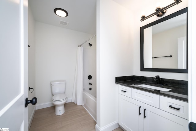 full bathroom featuring shower / bath combo, vanity, and toilet