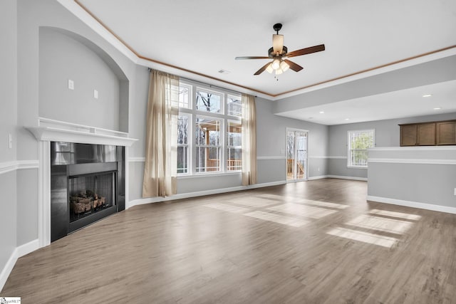 unfurnished living room with ceiling fan, ornamental molding, and hardwood / wood-style floors