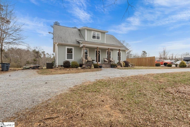 view of front of house featuring a front yard, cooling unit, and covered porch