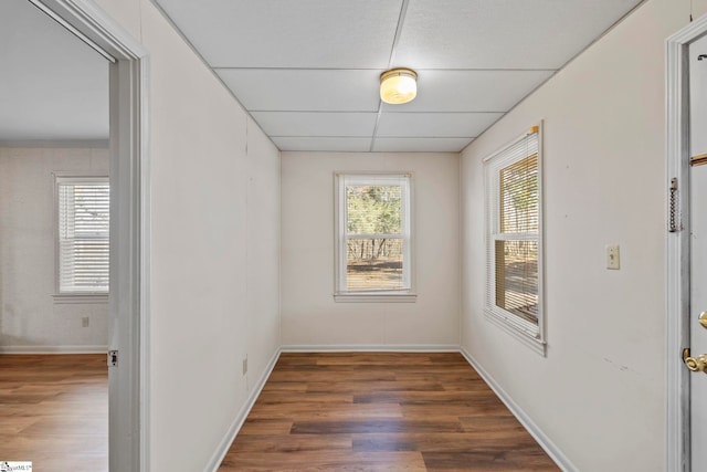 spare room with dark wood-type flooring and a paneled ceiling