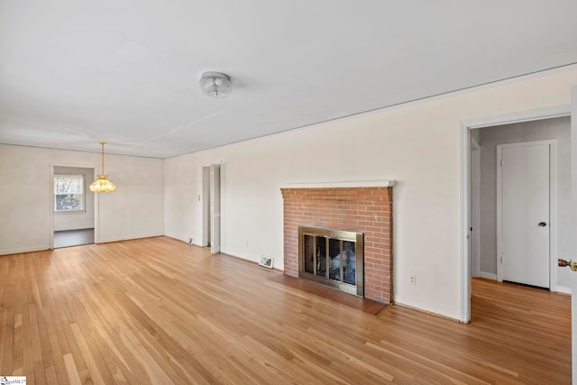 unfurnished living room with a fireplace and light hardwood / wood-style floors