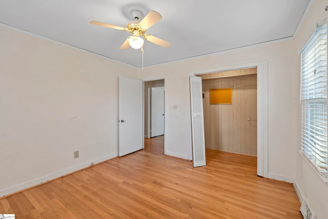 unfurnished bedroom featuring ornamental molding, light wood-type flooring, ceiling fan, and a closet