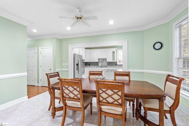 tiled dining space featuring crown molding and ceiling fan