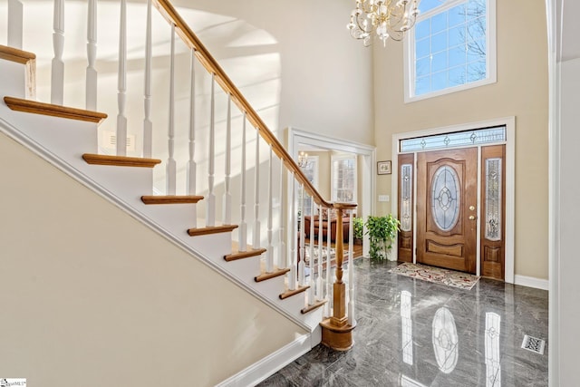 foyer with a high ceiling and an inviting chandelier