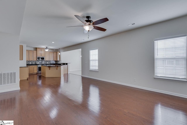 unfurnished living room with ceiling fan and dark hardwood / wood-style flooring