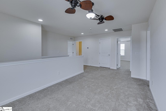 spare room featuring ceiling fan and light colored carpet