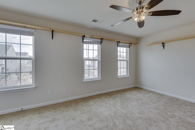 empty room featuring light colored carpet and ceiling fan