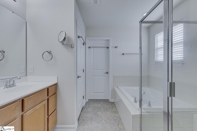 bathroom featuring vanity and tiled bath