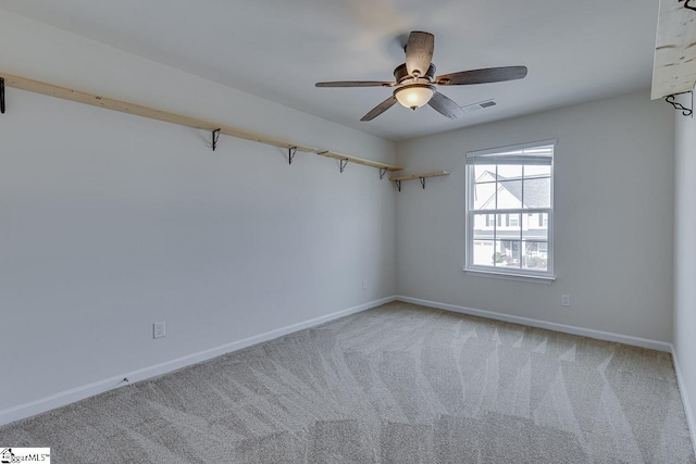 carpeted spare room featuring ceiling fan