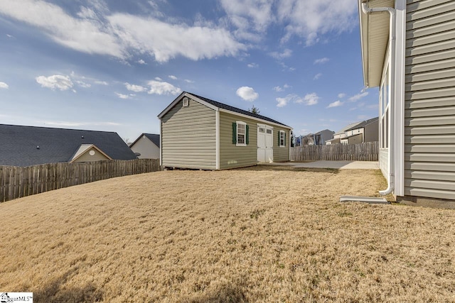 rear view of house featuring an outbuilding, a patio area, and a lawn