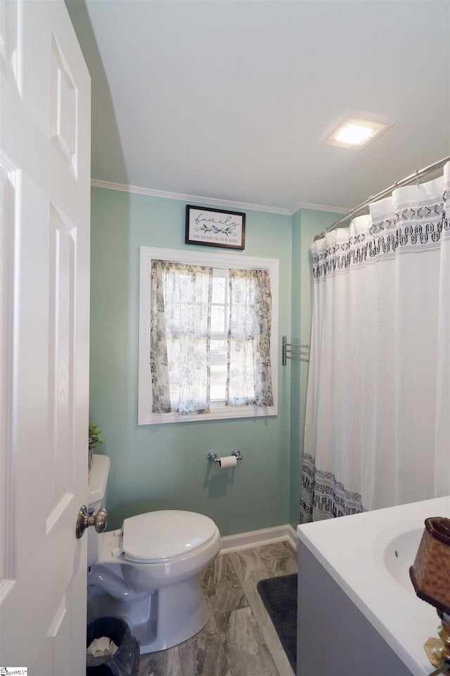 bathroom with vanity, ornamental molding, and toilet