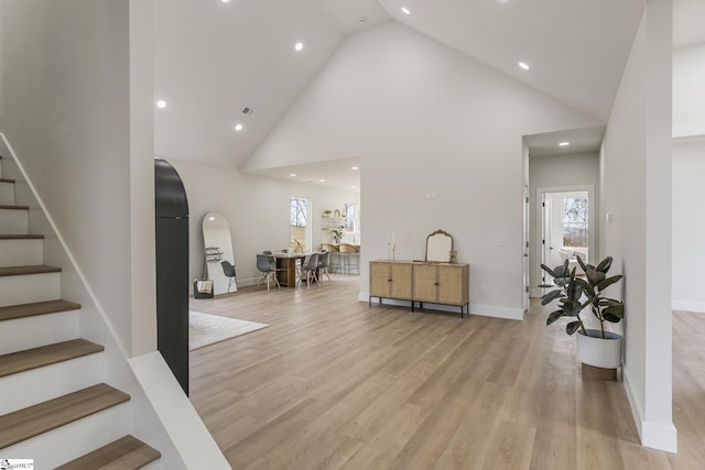 interior space featuring light wood-type flooring and high vaulted ceiling