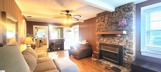 living room featuring hardwood / wood-style floors, a fireplace, wooden walls, ceiling fan, and beam ceiling