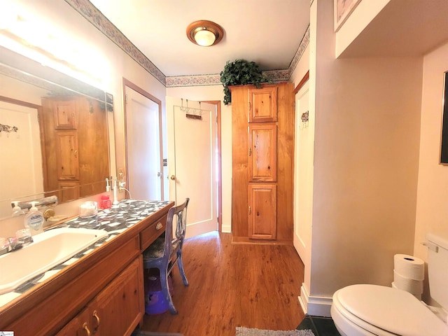 bathroom with vanity, toilet, and hardwood / wood-style floors