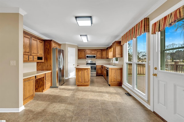 kitchen featuring crown molding, stainless steel appliances, sink, and a kitchen island