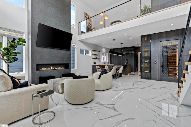 living room with a towering ceiling, a fireplace, and a wealth of natural light