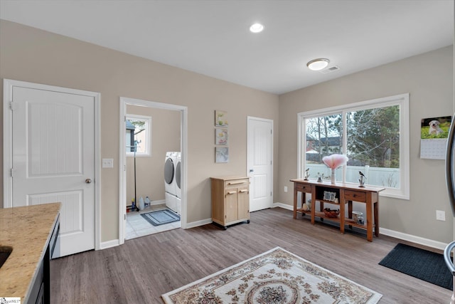 office with washing machine and clothes dryer and light hardwood / wood-style flooring