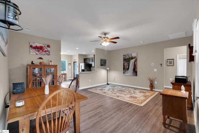 dining space with wood-type flooring and ceiling fan