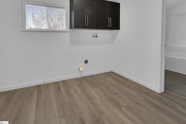 clothes washing area with cabinets, hookup for a washing machine, light wood-type flooring, and electric dryer hookup